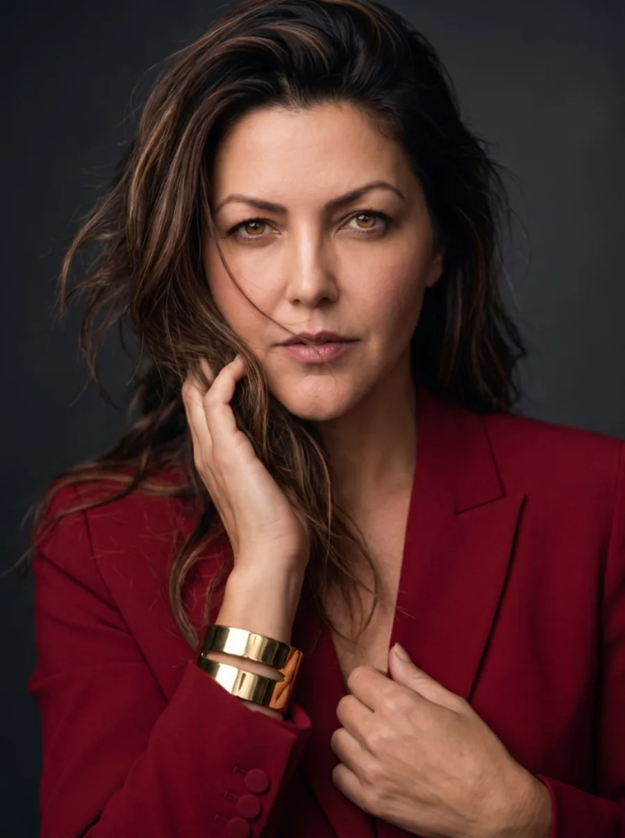 Retrato editorial de mulher com blazer burgundy e pulseira dourada